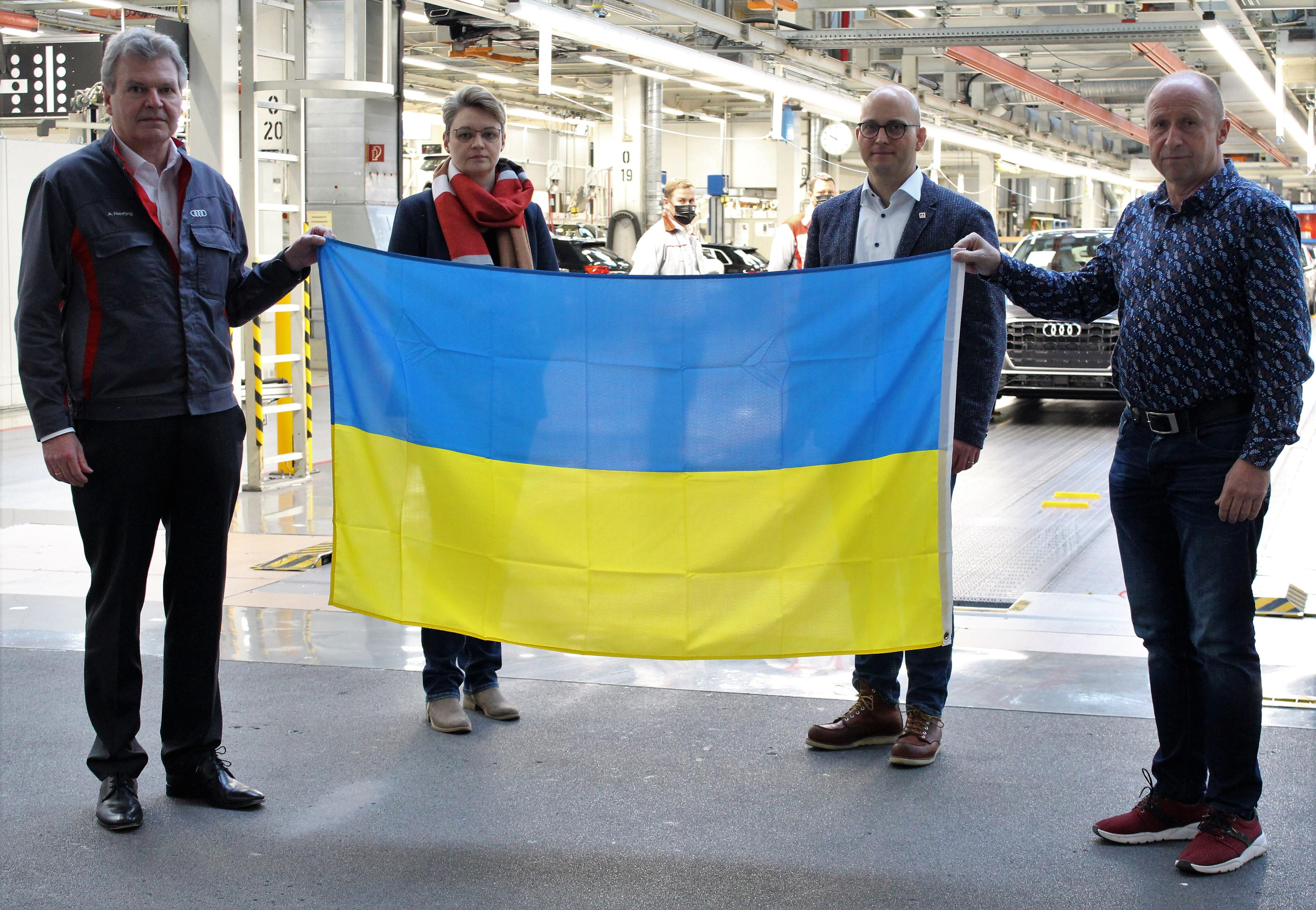 Schweigeminute bei Audi in Ingolstadt für die Opfer des Ukraine-Krieg: Der Vorsitzende der IG Metall Vertrauenskörperleitung bei Audi Jörg Schlagbauer (2.v.r.), seine Stellvertreterin und Mitglied des Vorstands der IG Metall Deutschland Karola Frank (2.v.l.) und der Montage-Betriebsrat Franz Eichhorn (re.) senden zusammen mit dem Werkleiter Achim Heinfling (li.) und Audianer*innen ein Zeichen für Frieden aus der Ingolstädter Produktion.