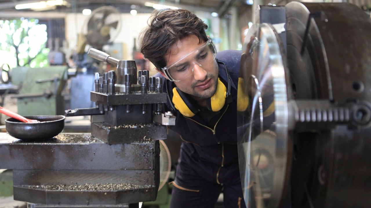 Beschäftigter in Werkstatt an einer Maschine
