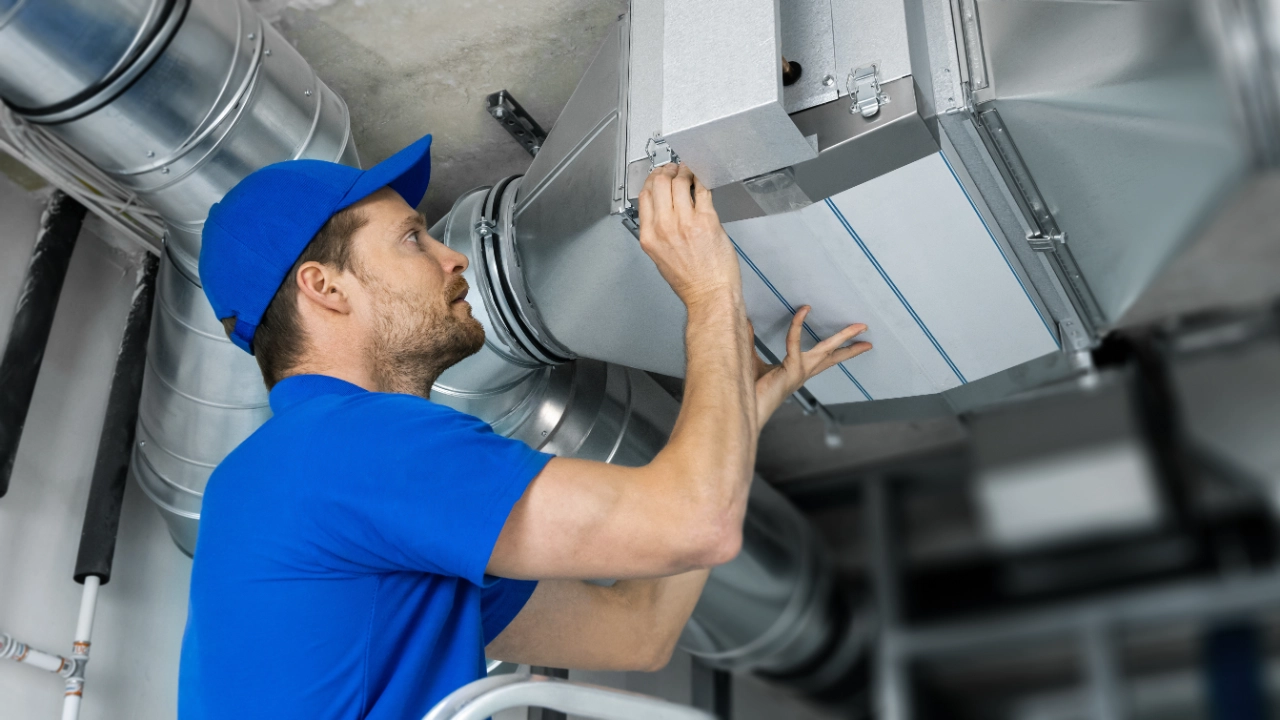 Ein Techniker repariert eine Lüftungsanlage