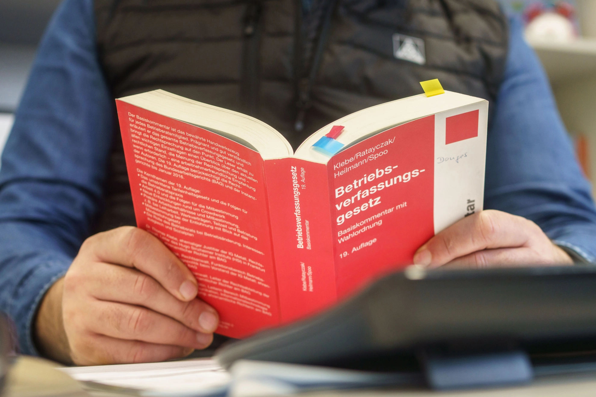 Betriebsrat Ercan Kaya liest im Betriebsverfassungsgesetz bei Donges in Darmstadt